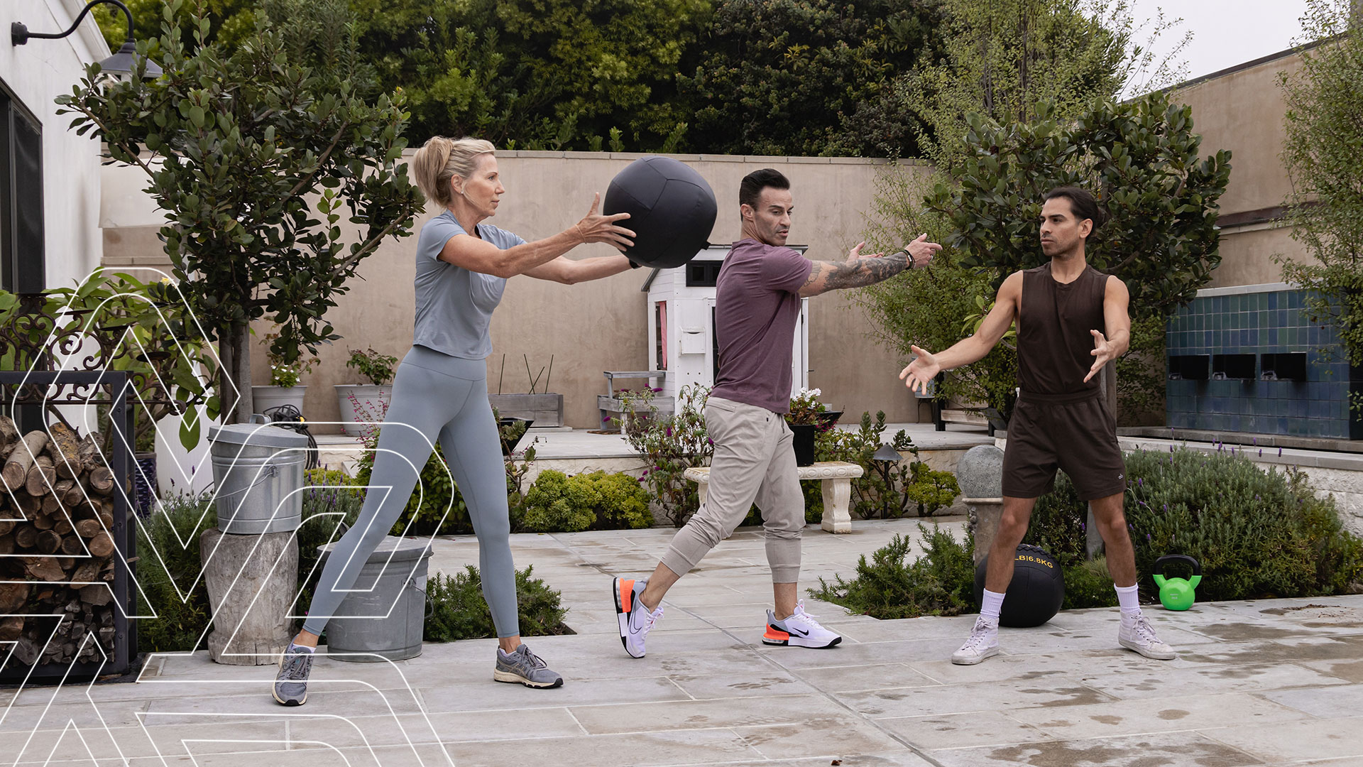 Woman throwing exercise ball to personal trainer Josh Charles